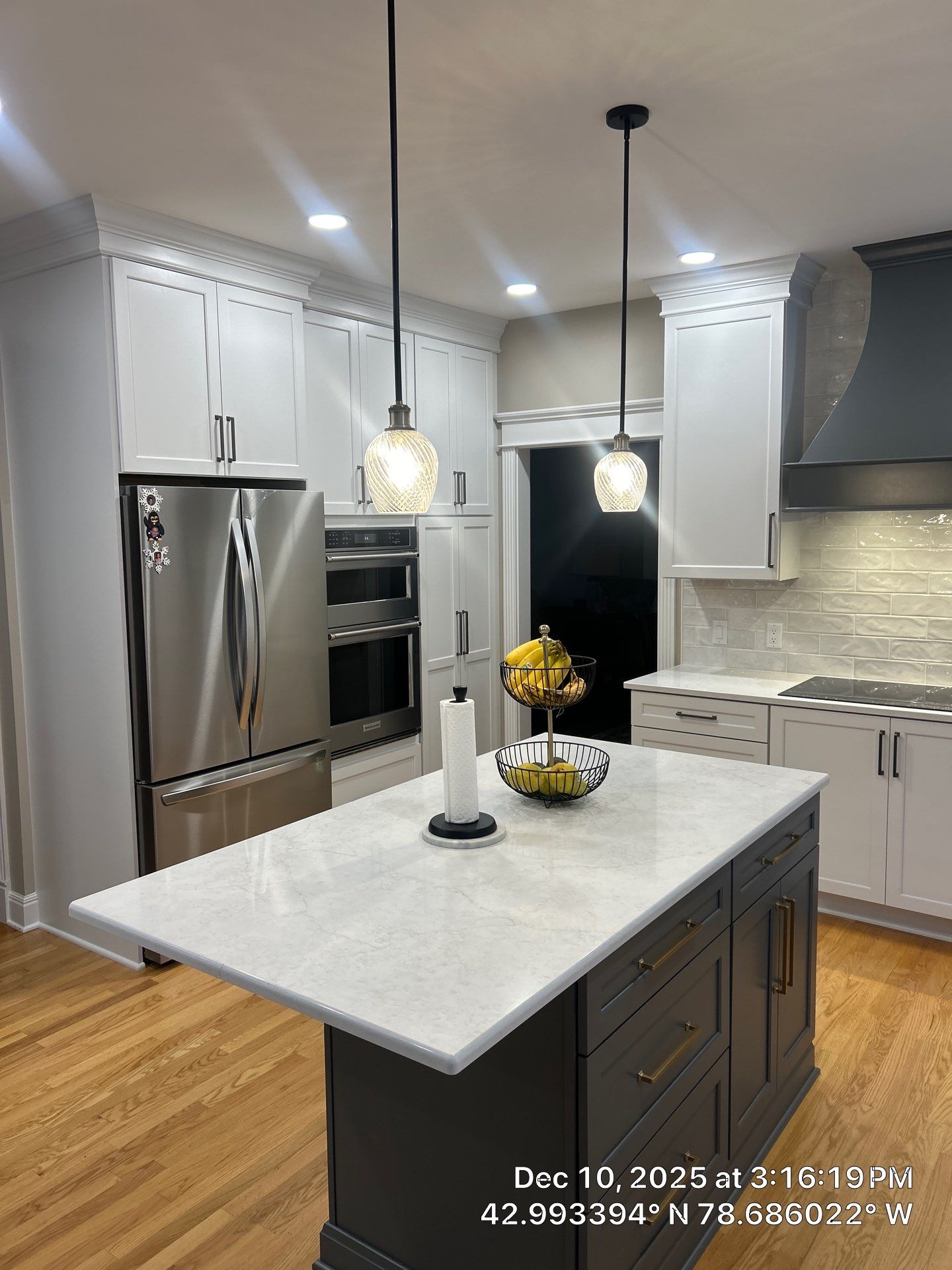 Remodeled open-concept kitchen with large island and white shaker cabinets in a Buffalo home.